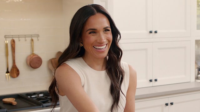 Brunette woman in kitchen smiling