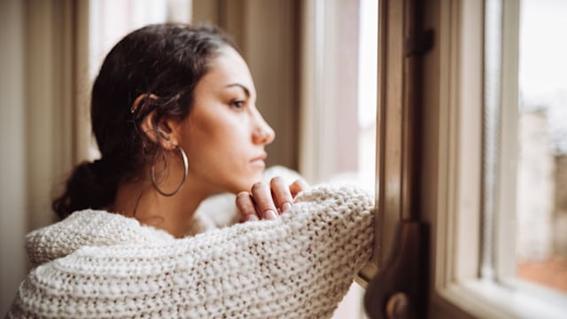pensive woman in front of the window