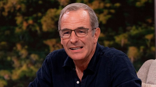 Man in blue shirt sitting on sofa in TV studio