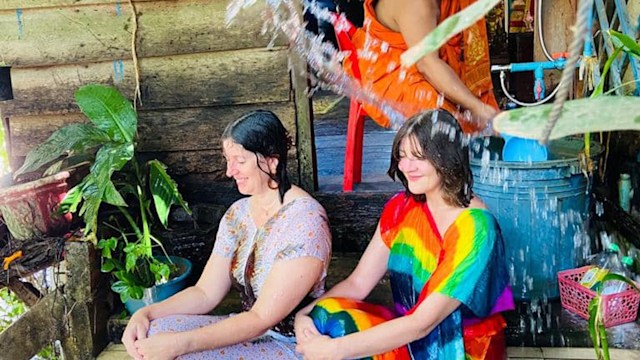 Kay and her friend Emma being blessed by a monk in Cambodia