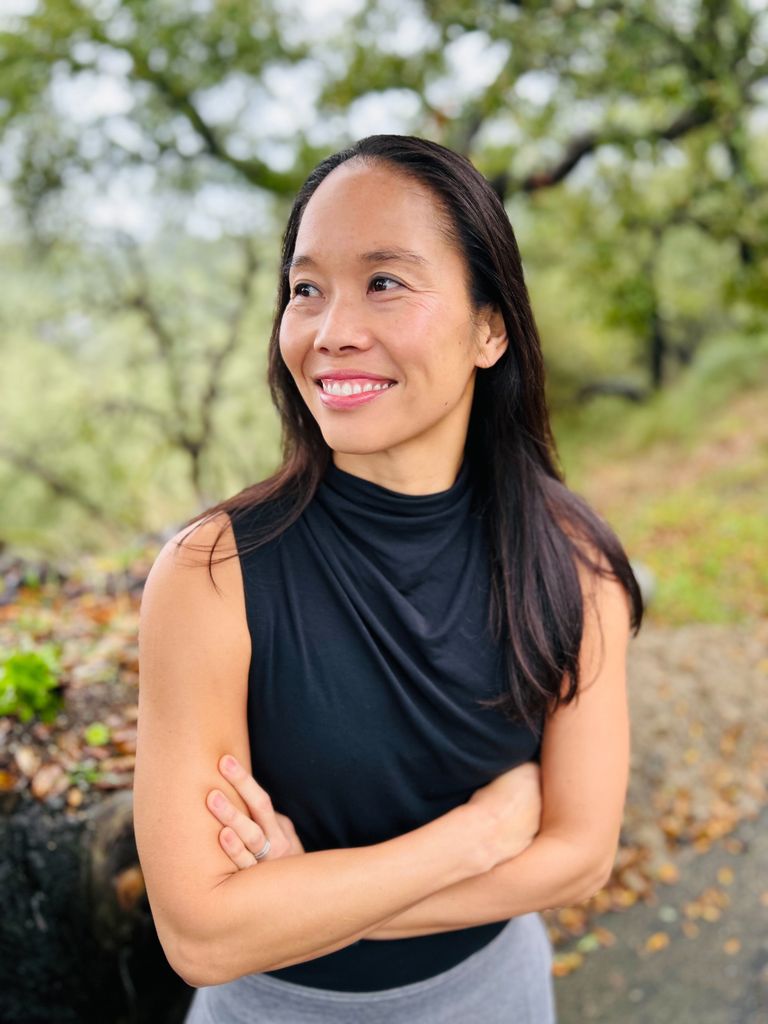 Woman with dark hair smiling and looking into the distance