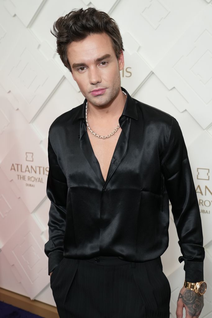 Liam Payne in a black silk shirt and necklace