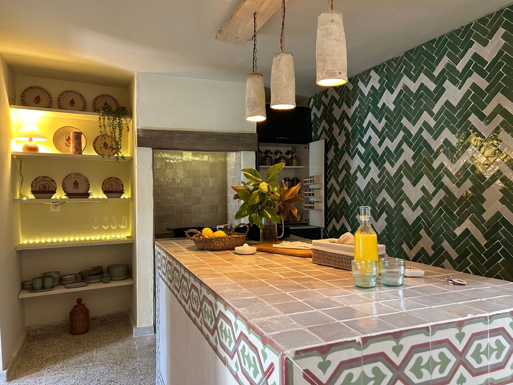 tiled kitchen with island and built-in shelves filled with crockery