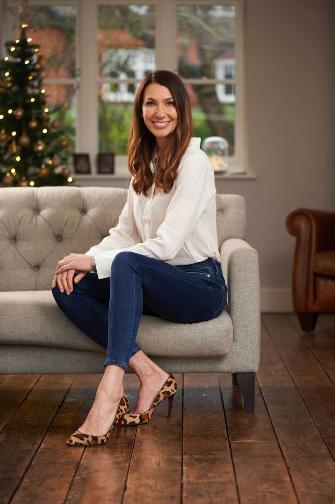 Woman sitting on a sofa in a white shirt and blue jeans 