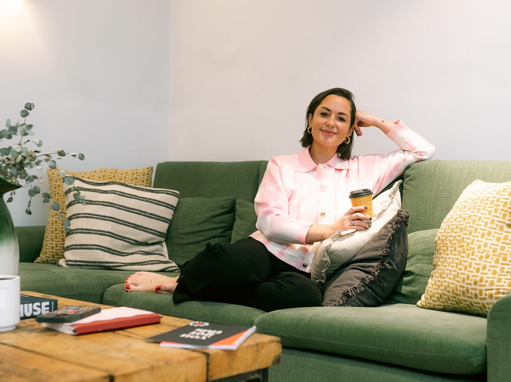 young woman sitting on the sofa with a coffee