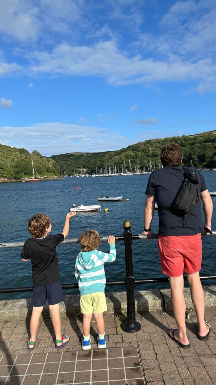 alex jones's husband charlie looking out to sea with two sons 