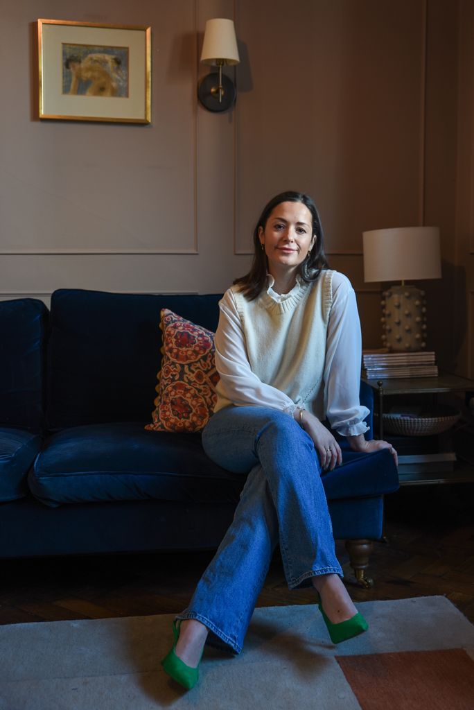 Young woman sitting on a sofa looking stylish