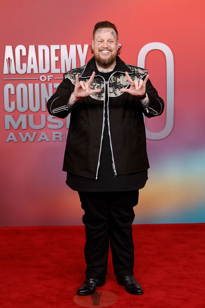 jelly roll posing on red carpet at acm awards