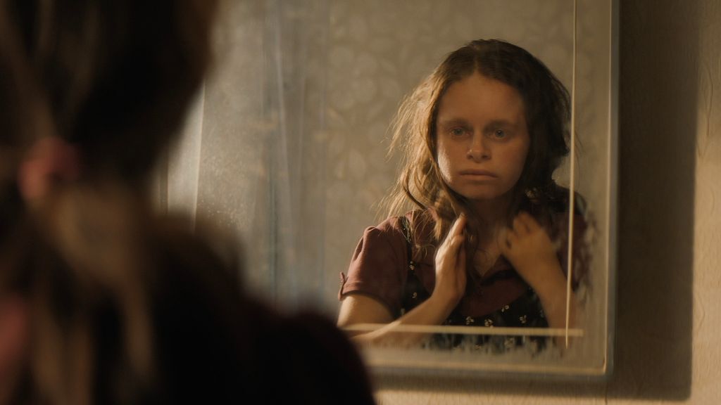 Young girl looking into mirror