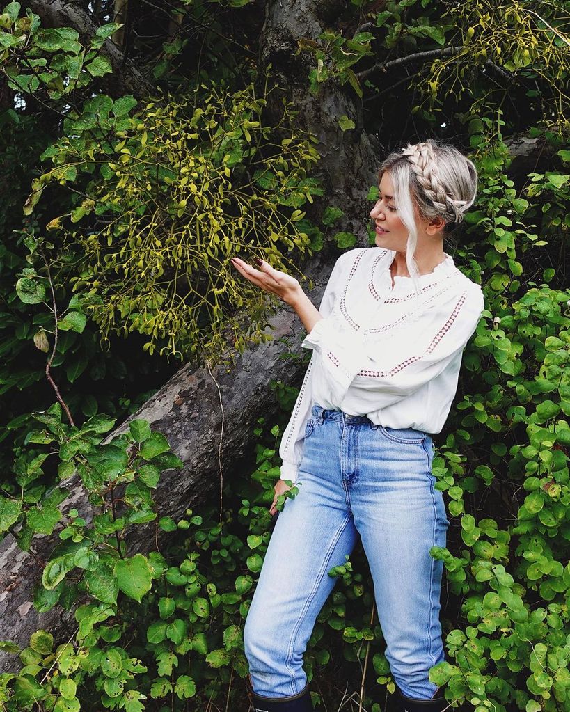 Young blonde woman gardening in jeans and a white top