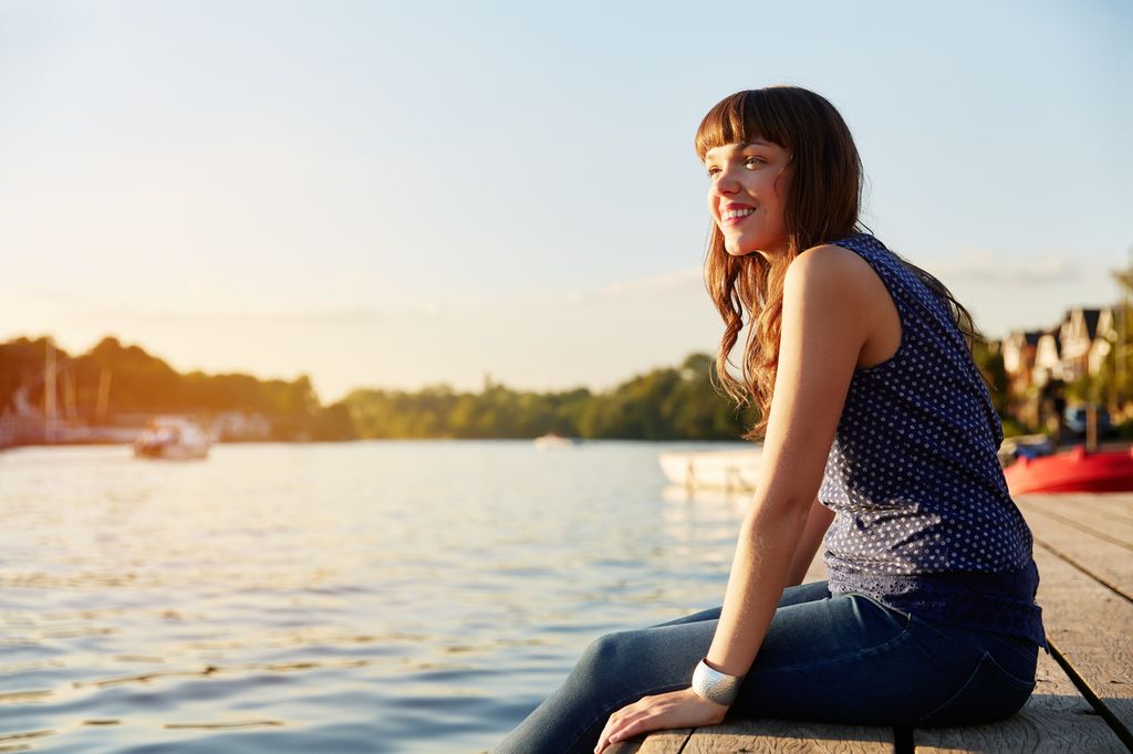 Woman sat on river jetty
