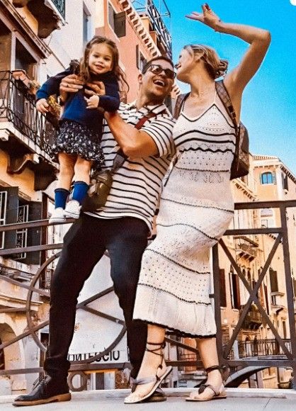 wilmer valderrama holding daughter in the air smiling at amanda pacheco 
