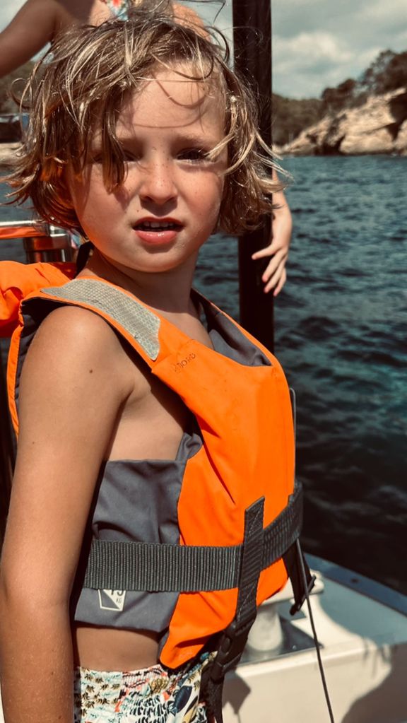Abbey Clancy's son wearing an orange life jacket