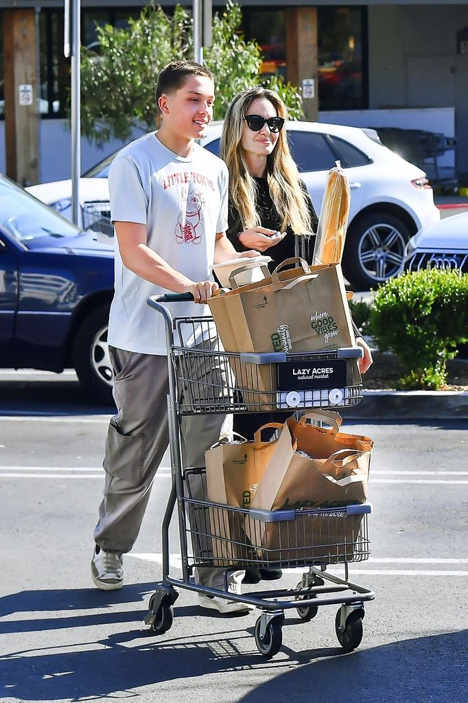 Knox towers over his mom in photo as they pushing shopping cart 