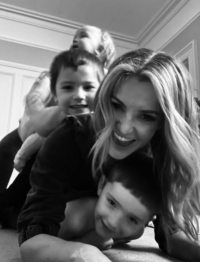 Black and white photo of Helen Skelton's children piled on her
