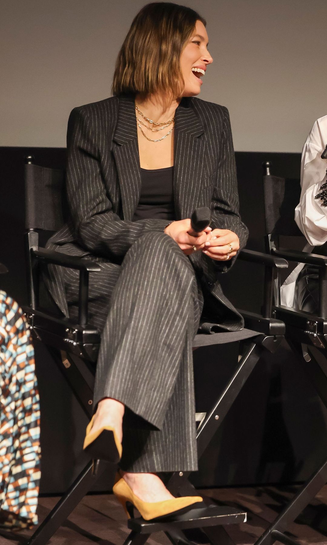Jessica Biel laughing in a pinstripe suit