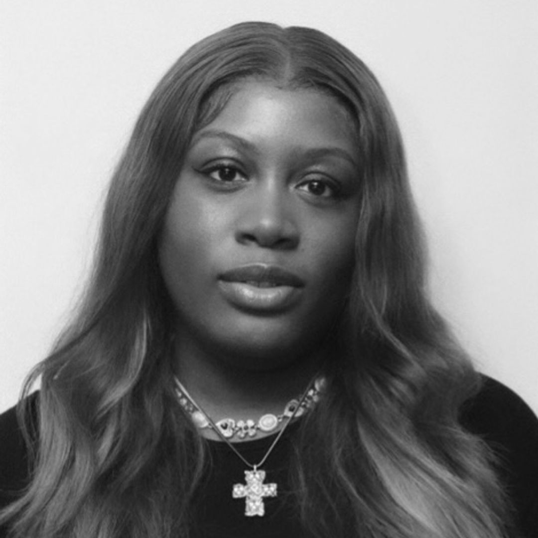 Hello! Fashion Beauty Writer Aaliyah Harry poses for her headshot in a black t-shirt