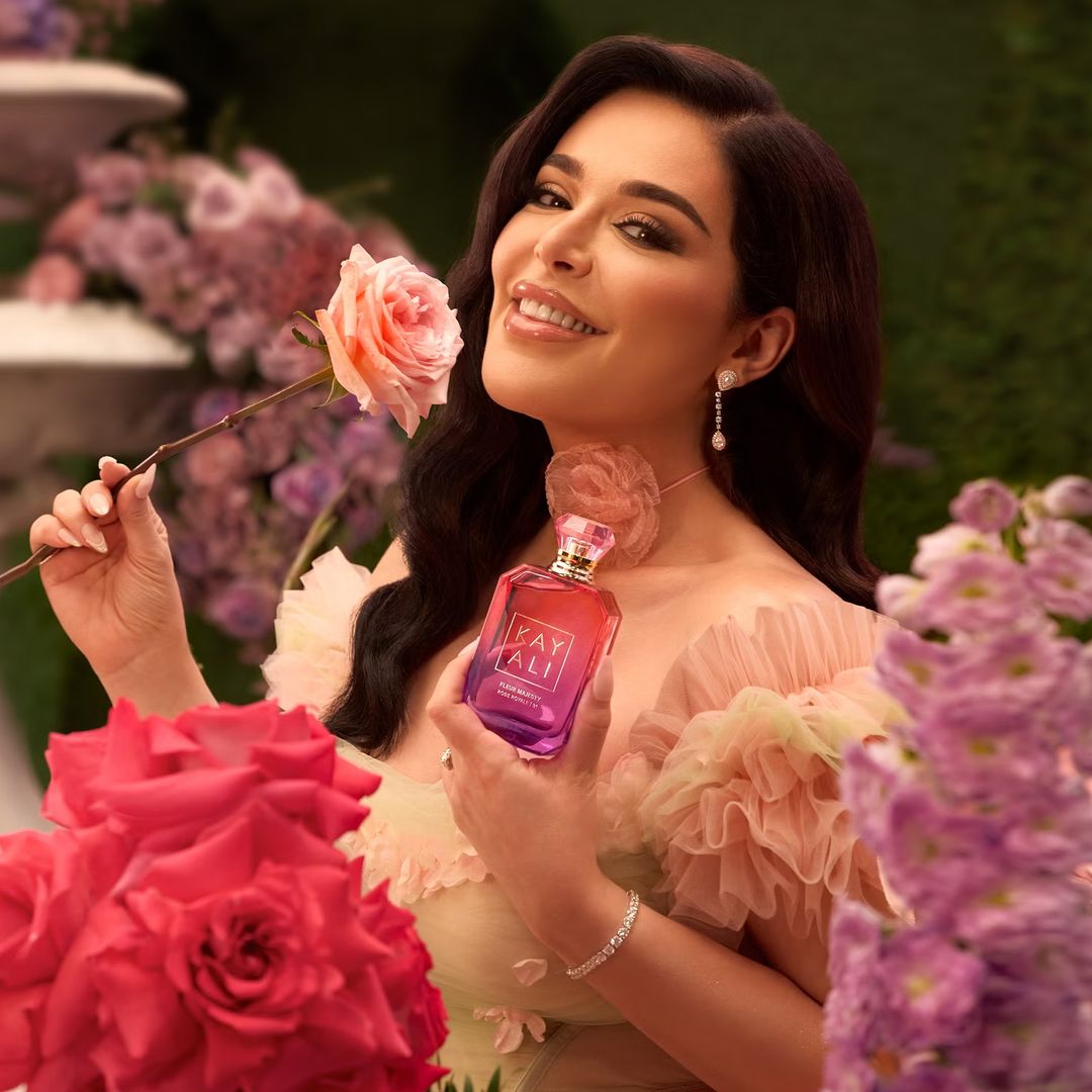 Mona Kattan surrounded by roses and florals 